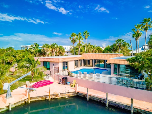 rear view of house with a water view and a patio area