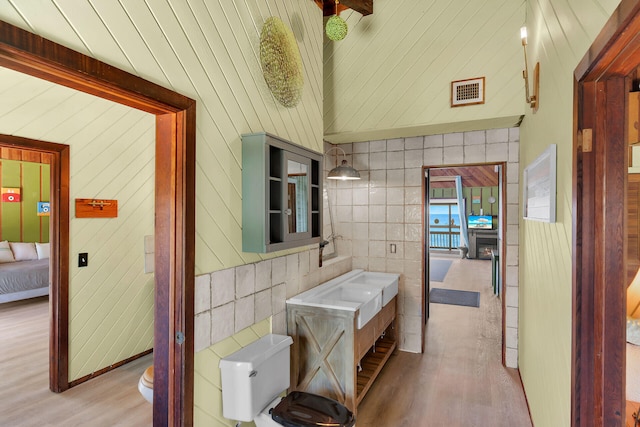 22542 Jolly Roger Dr, Cudjoe, FL 33042 - bathroom featuring toilet, wood finished floors, wooden walls, and ensuite bathroom