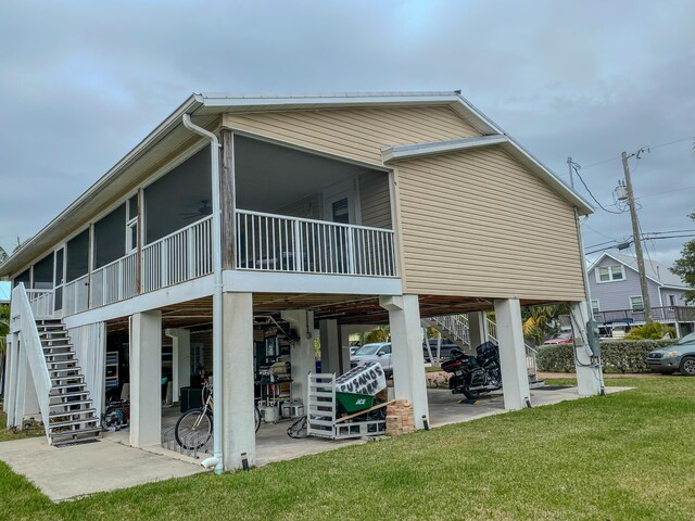 back of property featuring a sunroom, a yard, and a patio