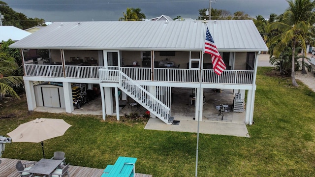 rear view of property featuring a sunroom, a yard, and a patio