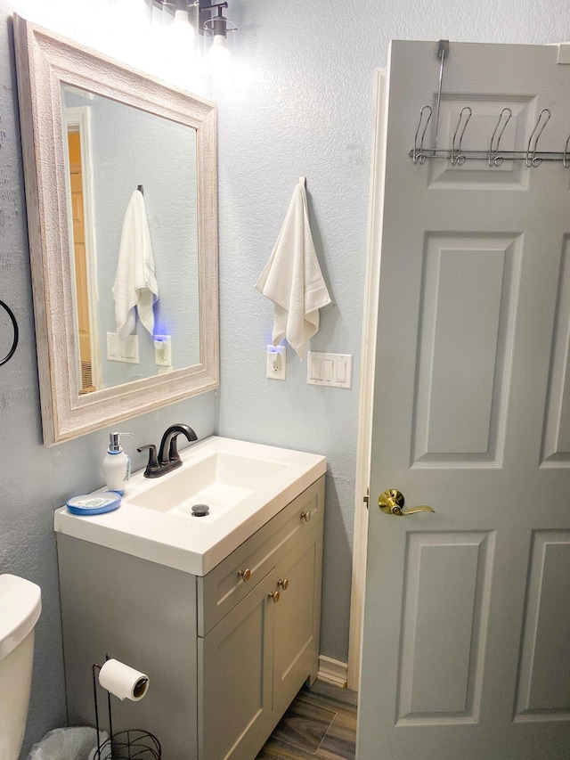 bathroom with vanity, hardwood / wood-style floors, and toilet