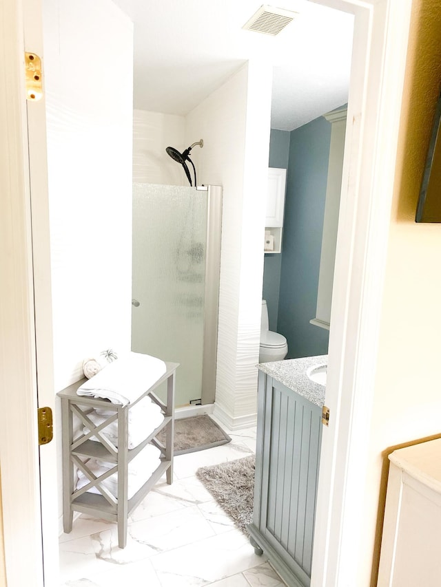 bathroom featuring vanity, toilet, and walk in shower