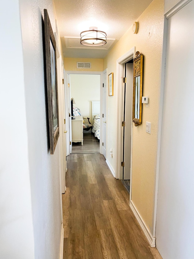 corridor featuring hardwood / wood-style flooring and a textured ceiling