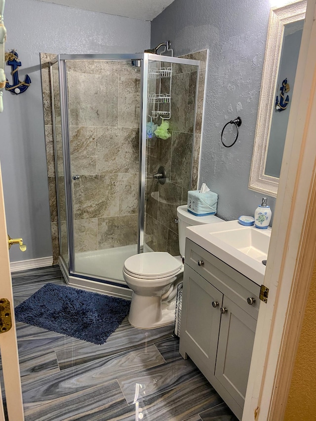 bathroom featuring vanity, an enclosed shower, and toilet