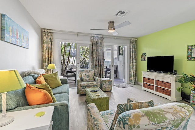 living room with ceiling fan, plenty of natural light, and light hardwood / wood-style floors