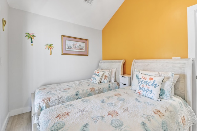 bedroom featuring hardwood / wood-style flooring and lofted ceiling