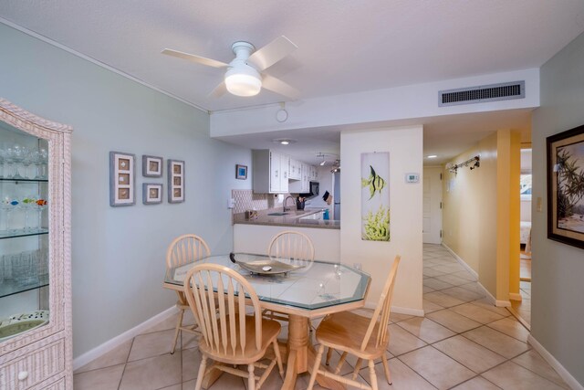 tiled dining area featuring sink, a barn door, and ceiling fan