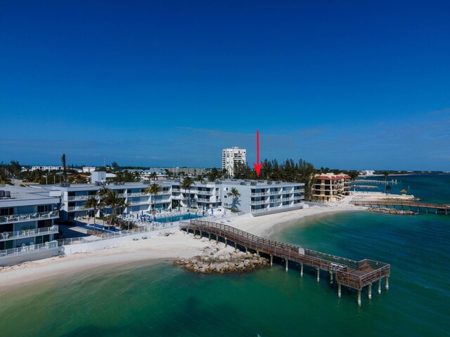 birds eye view of property with a water view and a beach view