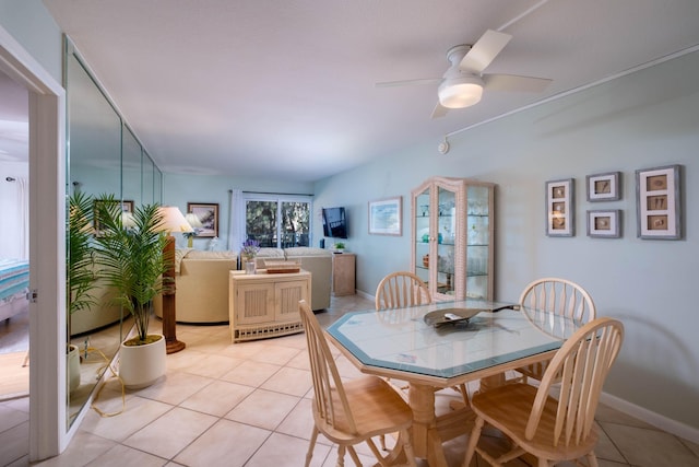 tiled dining space featuring ceiling fan