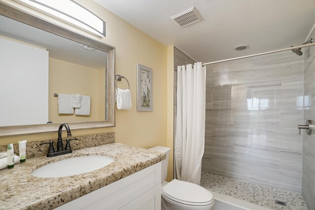 bathroom with a shower with curtain, vanity, and toilet