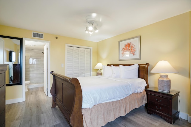 bedroom featuring ensuite bath, light hardwood / wood-style floors, and a closet