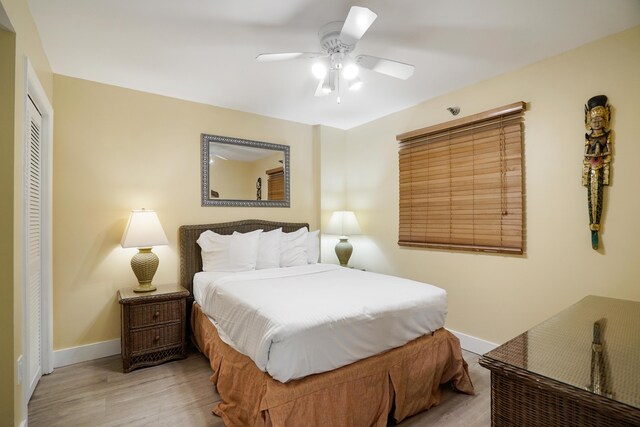 bedroom with ceiling fan, light wood-type flooring, and a closet