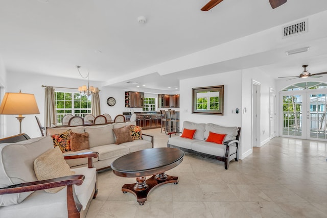 1330 Coury Dr, Key Colony, FL 33051 - living room featuring a ceiling fan, a chandelier, baseboards, and light tile patterned floors