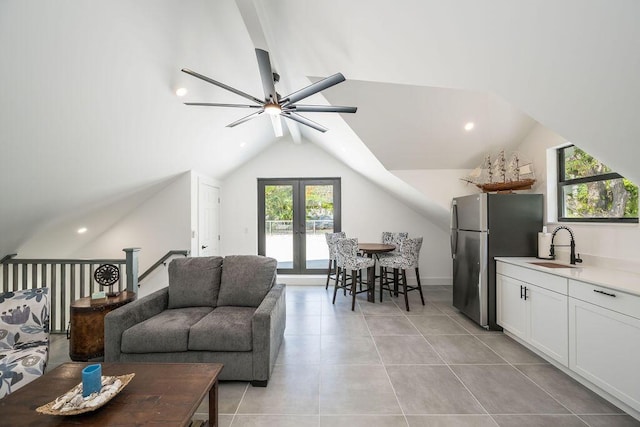 living room featuring vaulted ceiling, light tile patterned flooring, sink, ceiling fan, and french doors