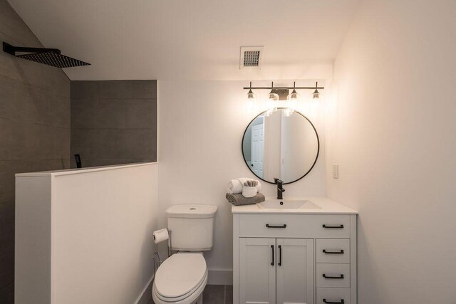 bathroom with walk in shower, vanity, and toilet