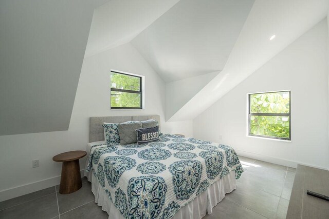 bedroom with lofted ceiling and light tile patterned floors