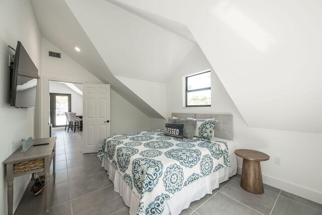 bedroom featuring tile patterned floors, lofted ceiling, and multiple windows