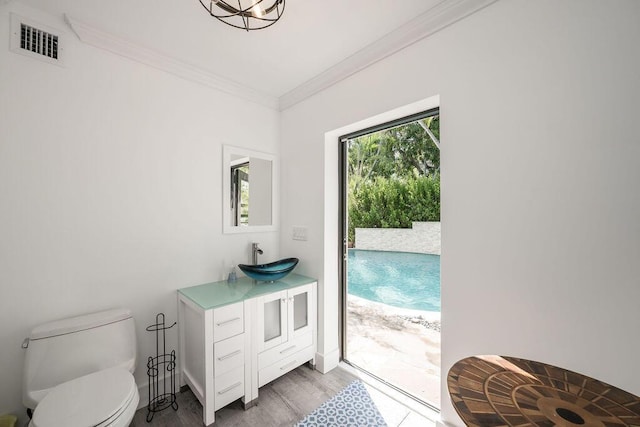 doorway with sink, ornamental molding, and hardwood / wood-style floors