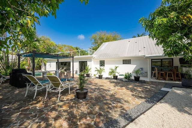 rear view of property with a pool and a patio area