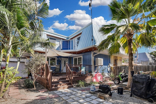 rear view of property featuring a wooden deck and fence