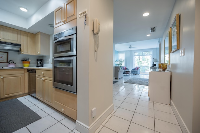 kitchen with light tile patterned floors, light brown cabinets, and double oven