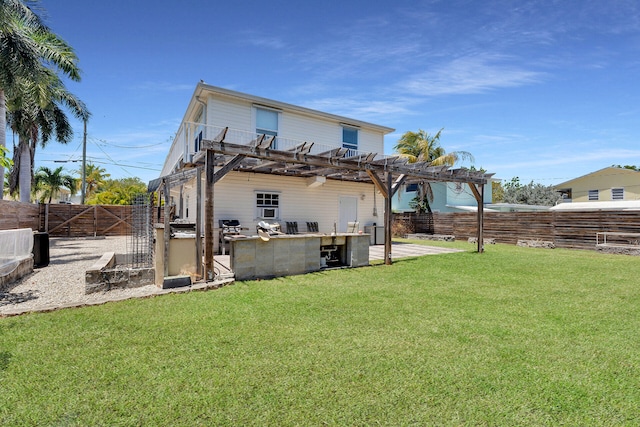 back of property with a pergola, a lawn, outdoor dry bar, a fenced backyard, and a patio area
