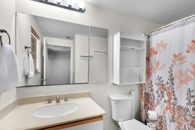 bathroom with curtained shower, vanity, and toilet