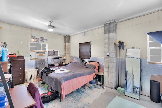 bedroom with concrete floors, visible vents, and cooling unit