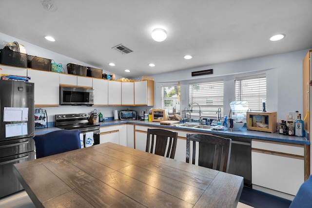 kitchen with white cabinets, recessed lighting, stainless steel appliances, and a sink