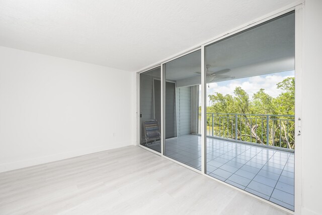 interior space featuring light hardwood / wood-style flooring, a wall of windows, and access to outside