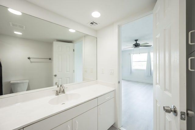 bathroom featuring vanity, hardwood / wood-style flooring, and toilet