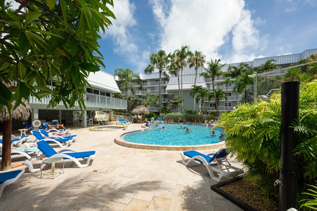 view of swimming pool featuring a jacuzzi and a patio