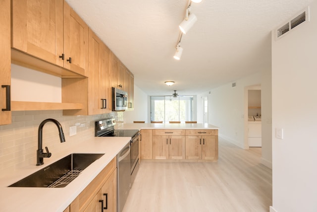 kitchen featuring light brown cabinetry, sink, backsplash, and stainless steel appliances