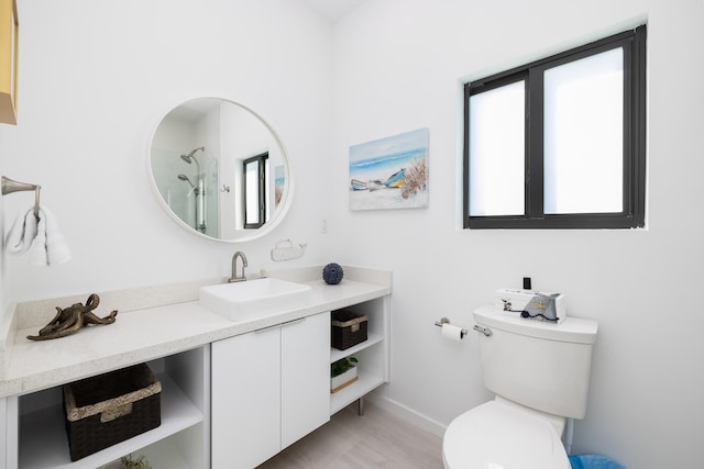 bathroom featuring vanity, toilet, and a shower