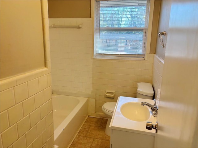 full bathroom with tile walls, a wainscoted wall, vanity, and toilet