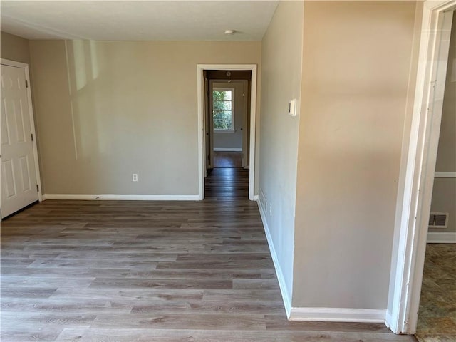 interior space with baseboards, visible vents, and wood finished floors