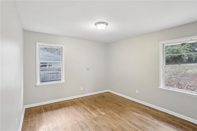 unfurnished room with wood finished floors and baseboards