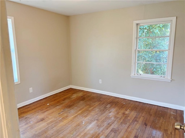 unfurnished room with wood-type flooring and baseboards