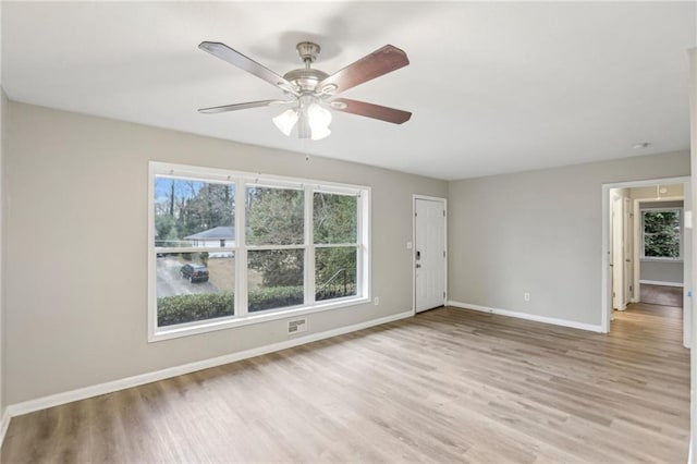 unfurnished room featuring ceiling fan, visible vents, baseboards, and light wood-style flooring