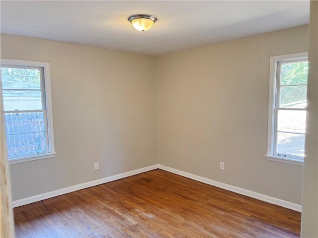 unfurnished room with wood finished floors and baseboards