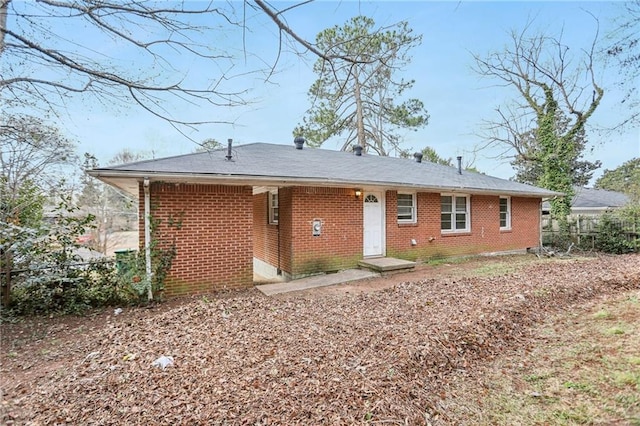 view of front of house featuring brick siding and fence