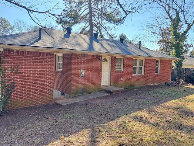 ranch-style home featuring brick siding and roof with shingles