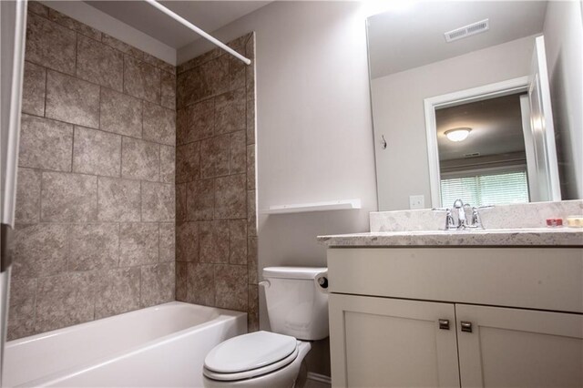 full bathroom featuring toilet, tiled shower / bath combo, and vanity