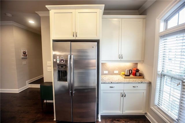 kitchen with stainless steel refrigerator with ice dispenser, white cabinets, ornamental molding, and tasteful backsplash