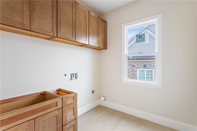 washroom with electric dryer hookup, baseboards, washer hookup, and cabinet space
