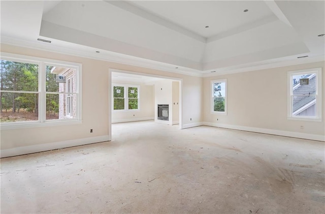 unfurnished living room featuring a tray ceiling, visible vents, and baseboards