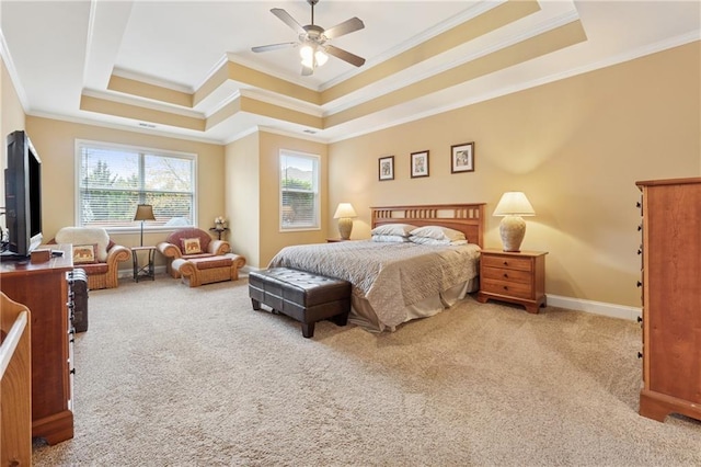 carpeted bedroom with baseboards, ornamental molding, a ceiling fan, and a tray ceiling