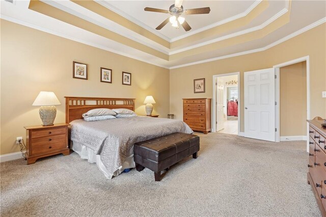 bedroom with ornamental molding, a tray ceiling, and carpet flooring