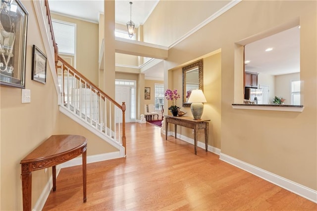 foyer entrance with stairway, baseboards, recessed lighting, and light wood-style flooring