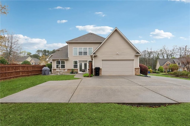 back of house with french doors, a yard, fence, concrete driveway, and an attached garage